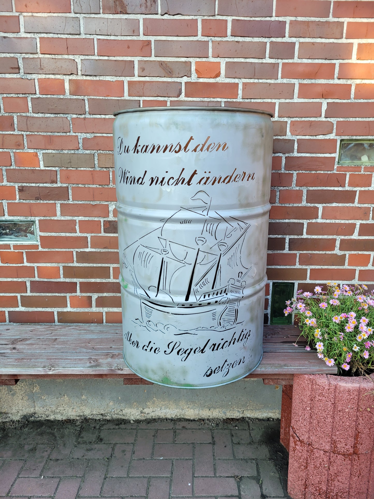 Feuertonne mit Schiff als Motiv und einem Schriftzug